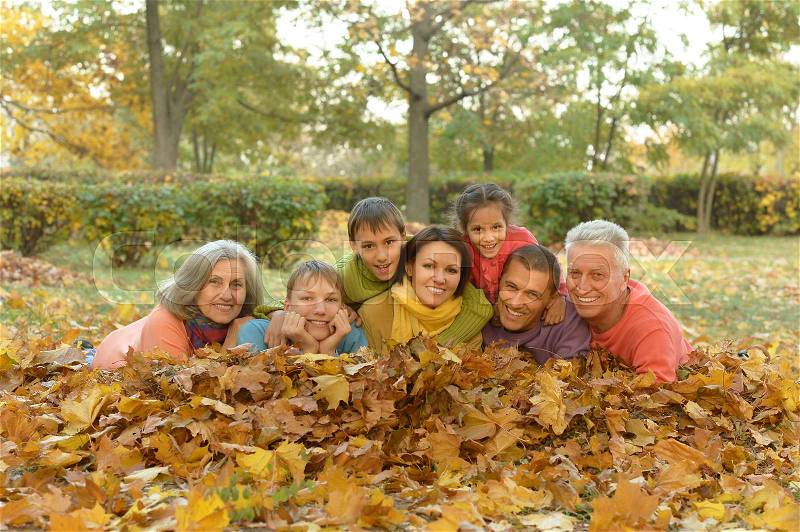 Happy smiling family relaxing in autumn forest, stock photo