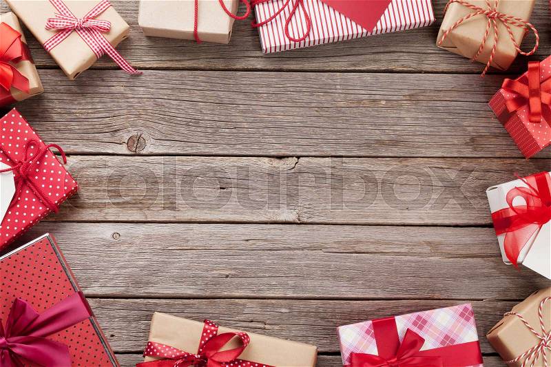 Christmas gift boxes frame greeting card on wooden table. Top view with copy space for your greetings, stock photo