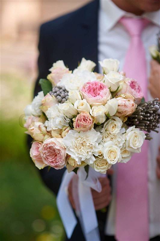 Groom holds the beautiful bride bouquet in wedding morning, stock photo