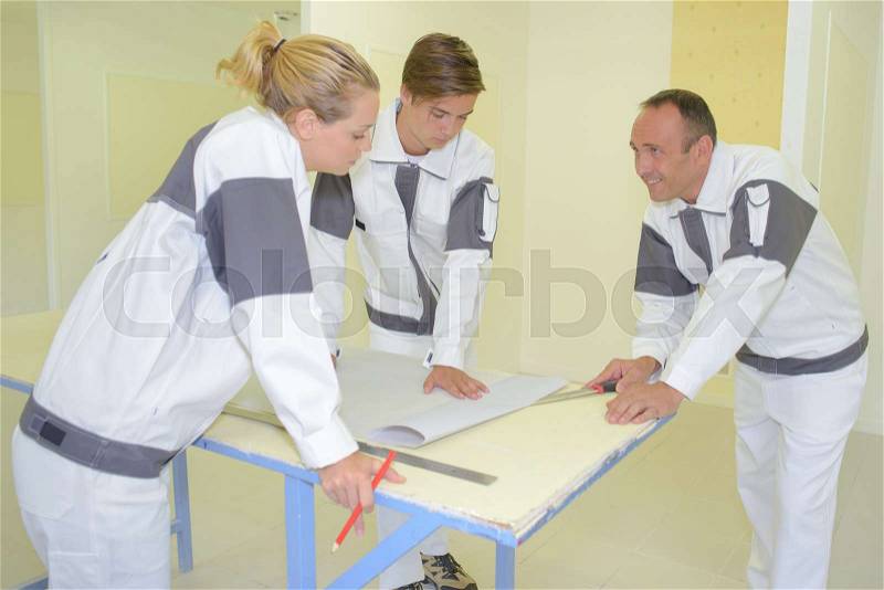 Team of decorators in discussion around a table, stock photo