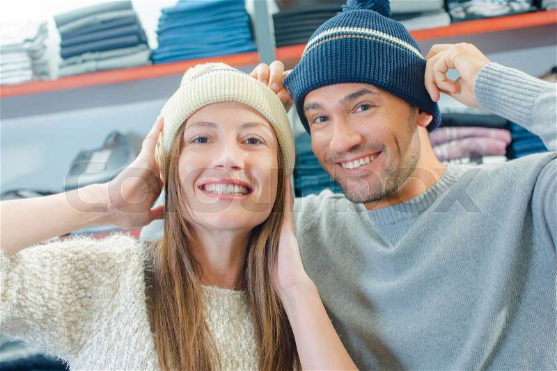 Couple in shop trying on beeny hats, stock photo