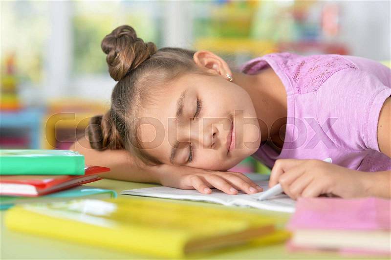 Cule girl fell asleep while she was doing her homework, stock photo