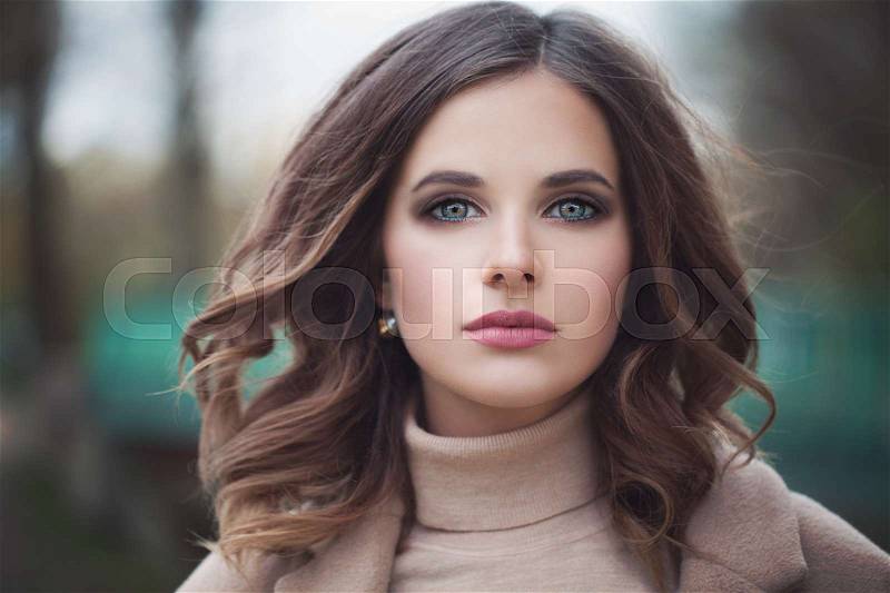 Beautiful Woman Model with Windy Hair and Makeup Outdoors. Spring time, stock photo