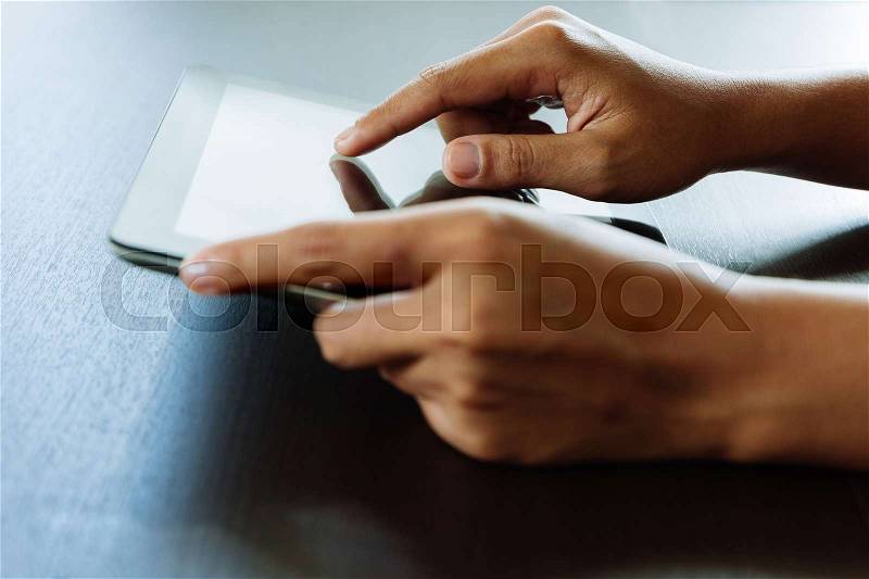 Close-up hand using tablet, selective focus finger touching on tablet display, stock photo