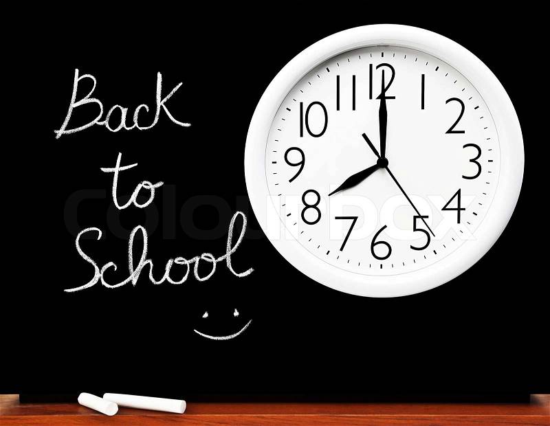 Back to school concept, handwriting on a black chalkboard with big white clock, stock photo