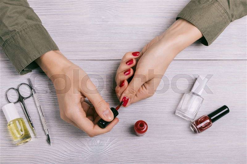 Close-up of female hands painted nails with red lacquer, stock photo