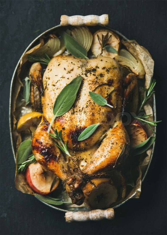 Oven roasted whole chicken with apples, onion and sage, stock photo