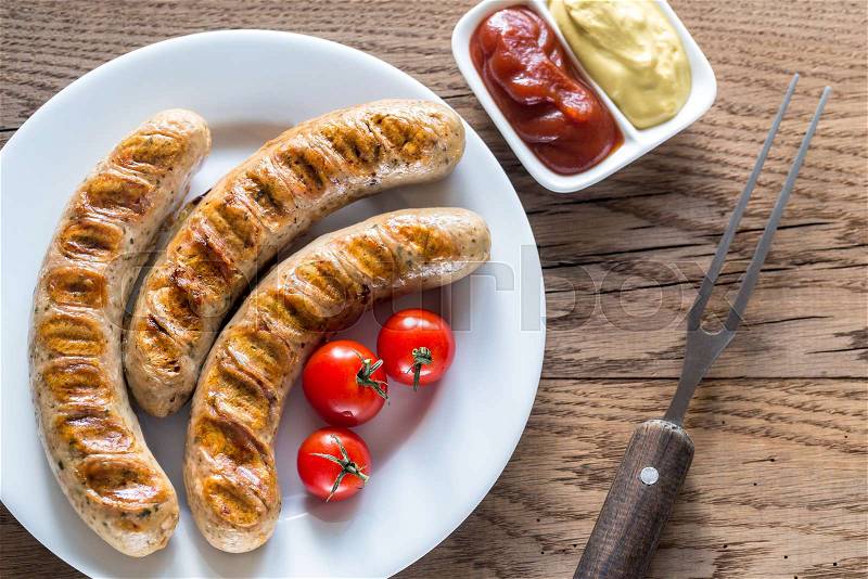 Grilled sausages with tomato and mustard sauce, stock photo