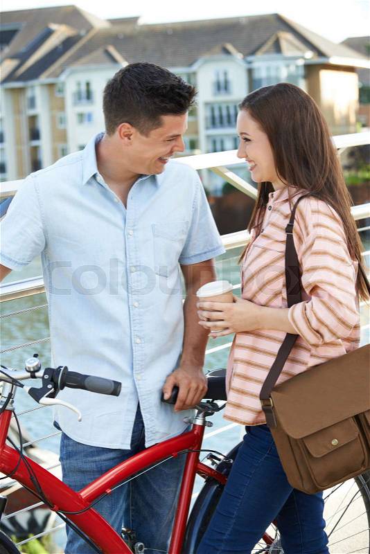 Young Couple Walking And Cycling To Work In Urban Setting, stock photo