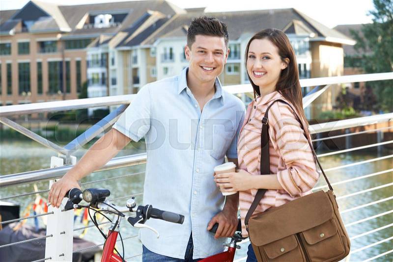 Young Couple Walking And Cycling To Work In Urban Setting, stock photo