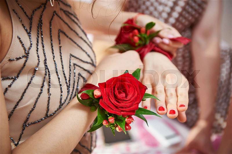 Bridesmaids with rose on hand helps to tie a flower, stock photo