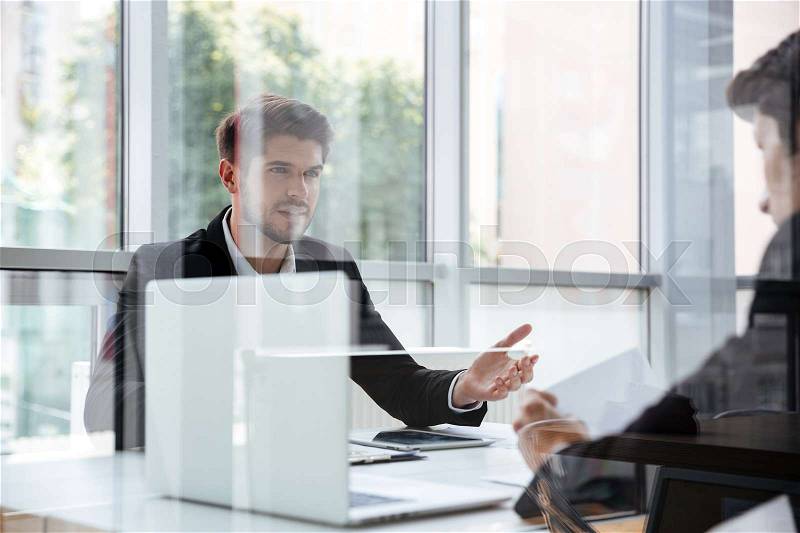 Two handsome young businessmen with laptop on business meeting, stock photo