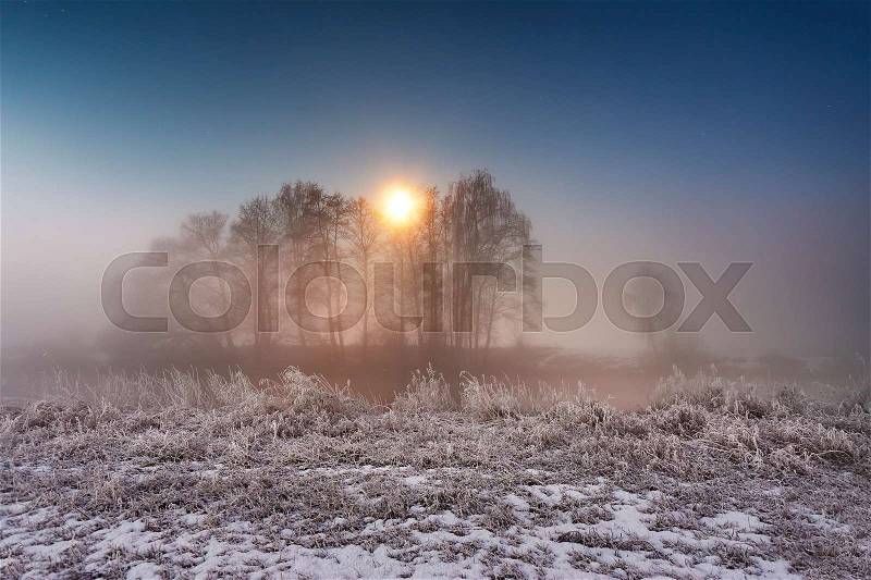 Moonlight in the winter night. Fog and mist on snowy winter river in Belarus, stock photo