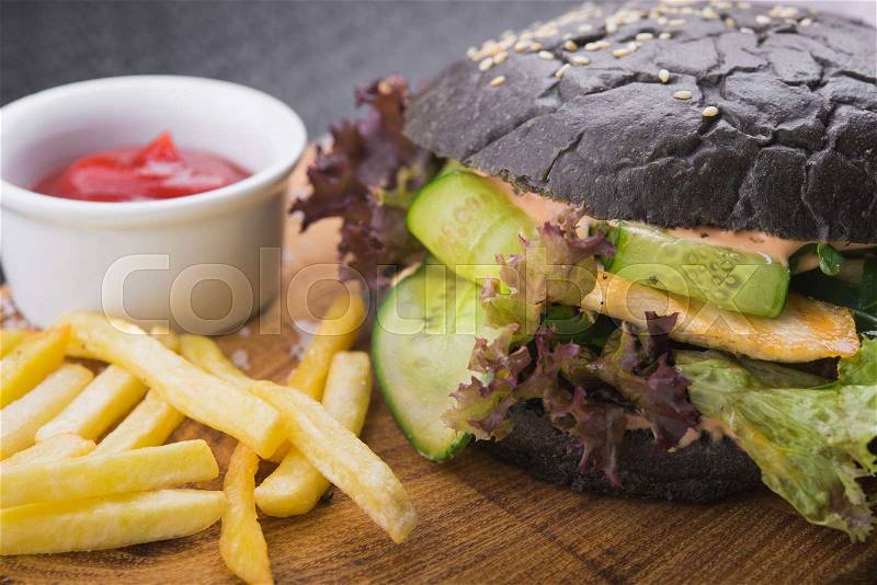 Diet burger with chicken, vegetables, and black bun. restaurant food background, stock photo