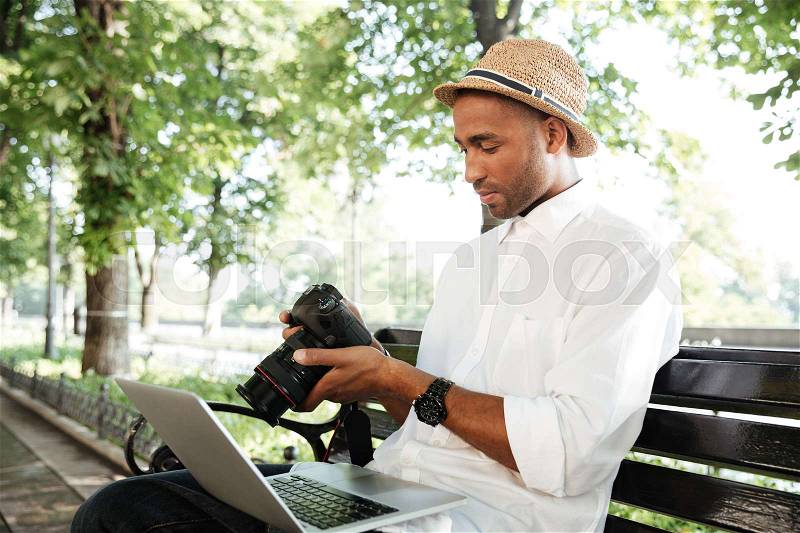 Fashion hipster with laptop in park. with camera, stock photo