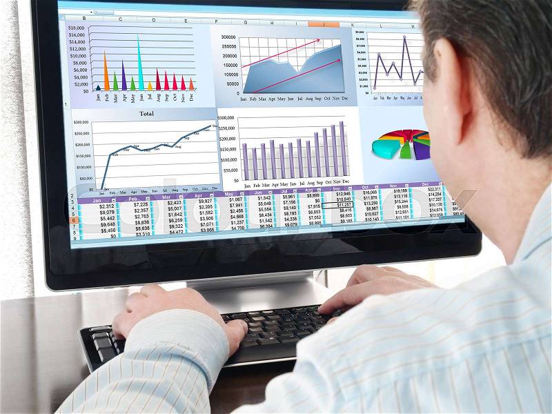 Analyzing financial data and charts on computer screen, stock photo