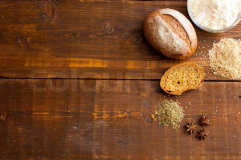 Fresh brown crispy bread with flour, loaf of bread and wheat grain on the wooden table , stock photo