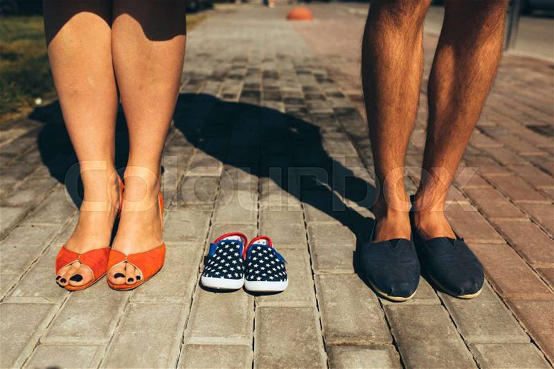 Stylish couple. Closeup of female and male feet in casual shoes on street background, stock photo