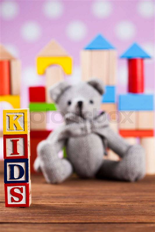 Colorful children toys on wooden background, stock photo