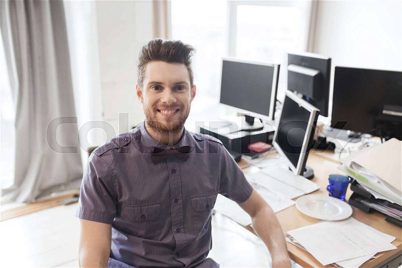 Business, startup and people concept - happy businessman or creative male office worker with computers, stock photo