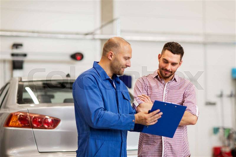 Auto service, repair, maintenance and people concept - mechanic with clipboard talking to man or owner at car shop, stock photo