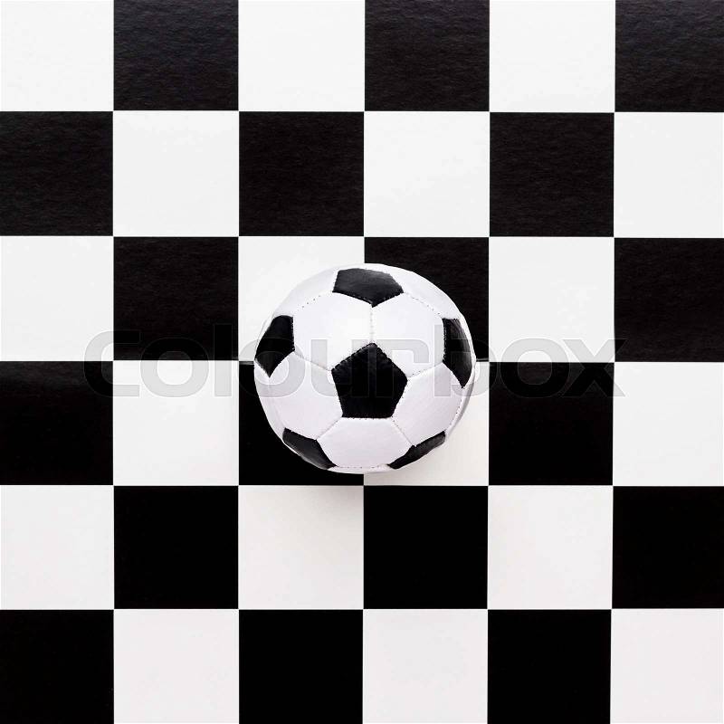 Soccer ball on chequered black and white pattern, stock photo
