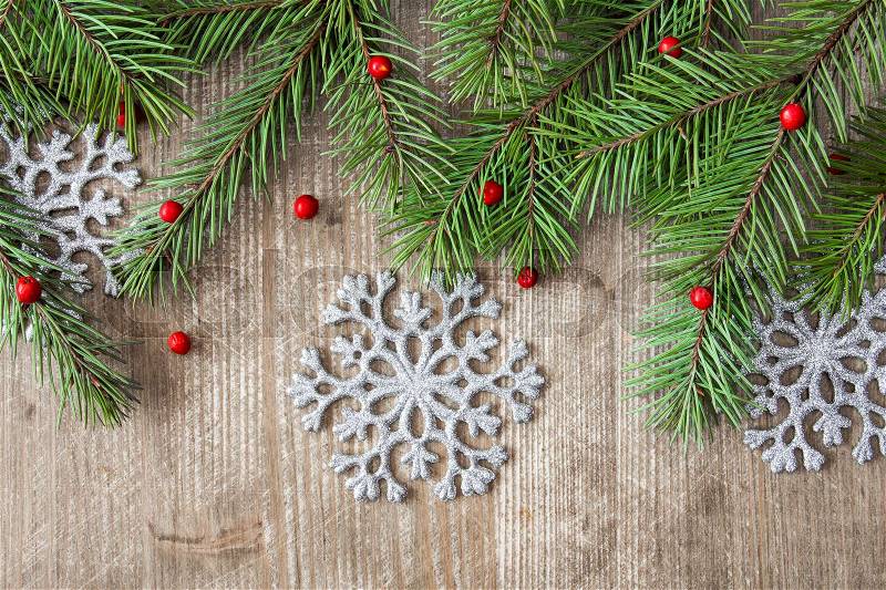 Wooden background with fir branch and silver snowflakes, stock photo