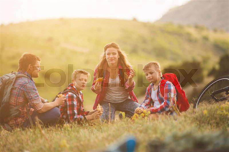 Happy family of four people eating fastfoodl in mountains. family concept, stock photo