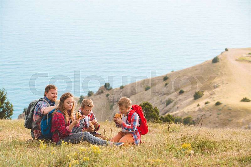 Happy family of four people eating fastfoodl in mountains. family concept, stock photo