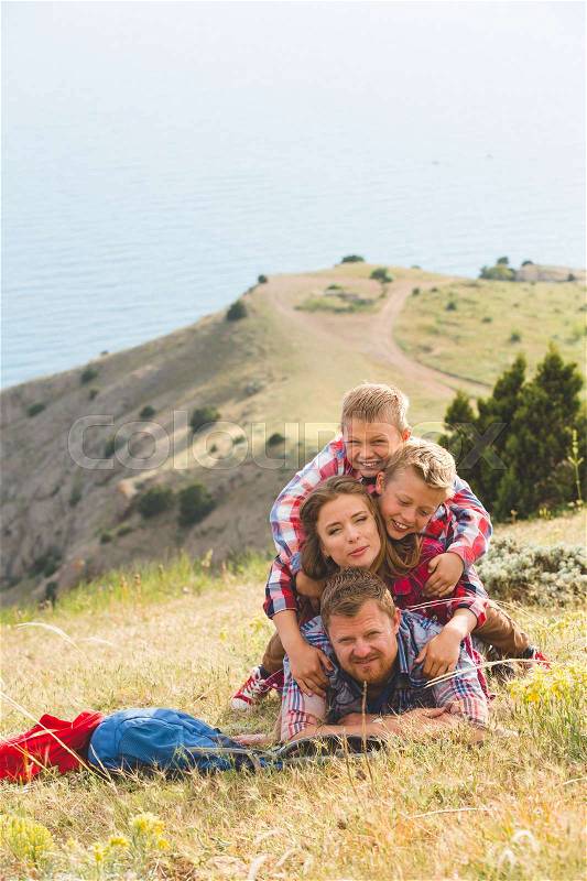 Happy family of four people looking to beautiful seascape in mountains. family concept, stock photo