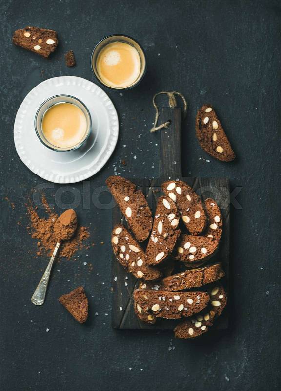 Dark chocolate and sea salt Biscotti with almond and two glasses of coffee espresso on dark stone background, top view, stock photo