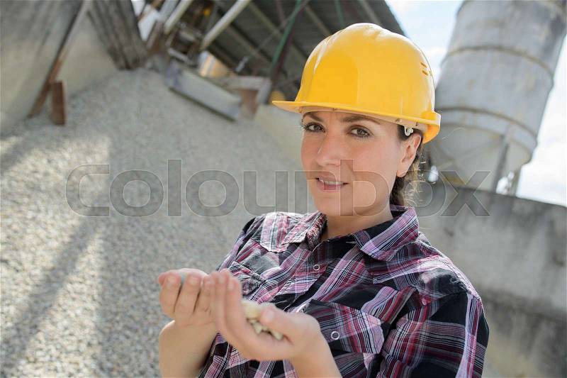 Construction factory with female engineer checking gravel, stock photo