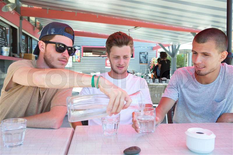 Three happy friends drink water to quench their thirst, stock photo