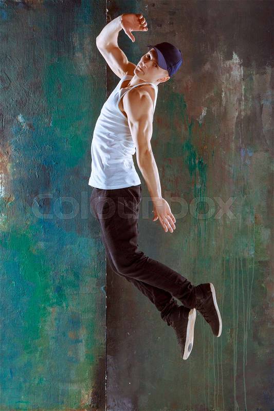 The man jumping and dancing fitness or hip hop choreography in green studio background, stock photo