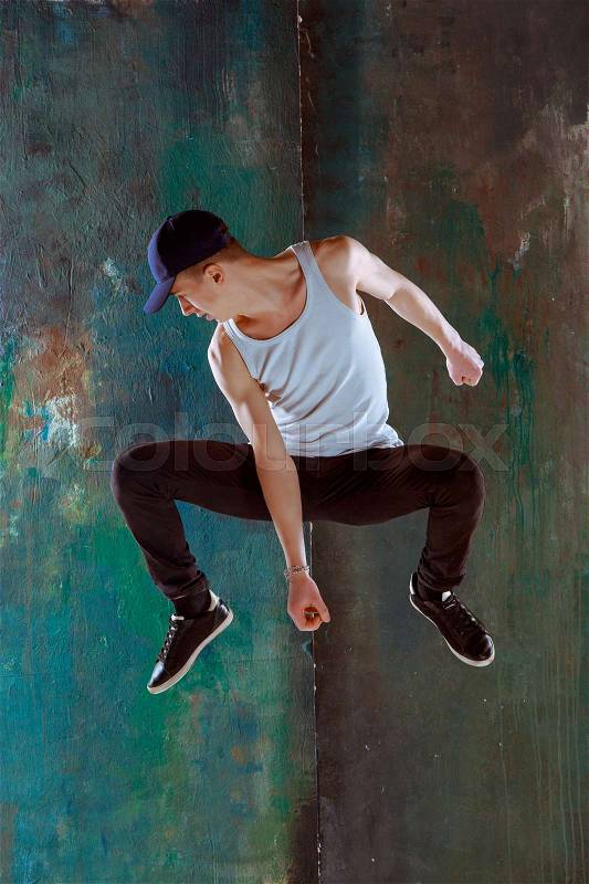 The man jumping and dancing fitness or hip hop choreography in green studio background, stock photo