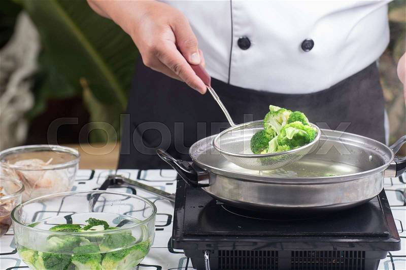 Chef scald broccoli with hot water / Stir fry Broccoli concept, stock photo