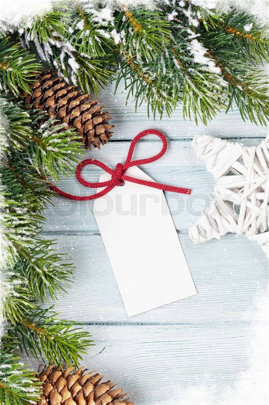 Christmas background with gift label and fir tree on wooden table. Top view with copy space. Gift wrapping, stock photo