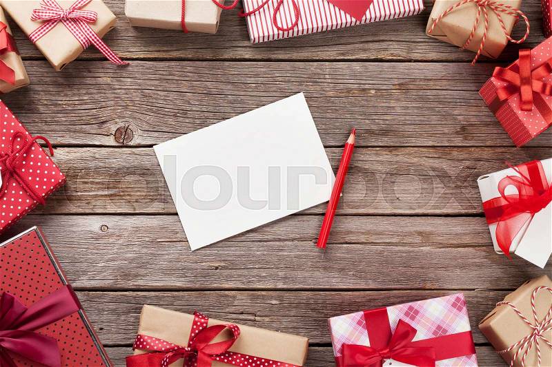 Christmas gift boxes and greeting card on wooden table. Top view with copy space. Gift wrapping, stock photo