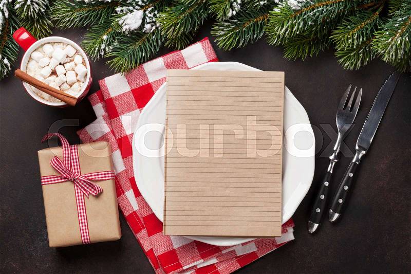 Christmas dinner plate, silverware, fir tree, hot chocolate with marshmallow. Top view with notepad for your recipe, stock photo