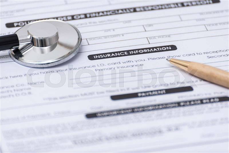 Close-up of Health Insurance Claim Application Form with pen and stetoscope, stock photo