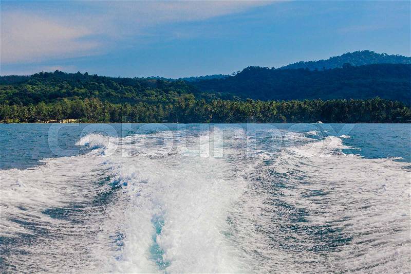 Water stream after speed boat. Trail on water surface behind of fast moving motor boat. Waves on blue sea, stock photo