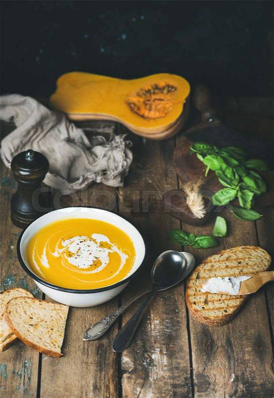 Pumpkin cream soup with fresh green basil, spices, grilled bread, stock photo