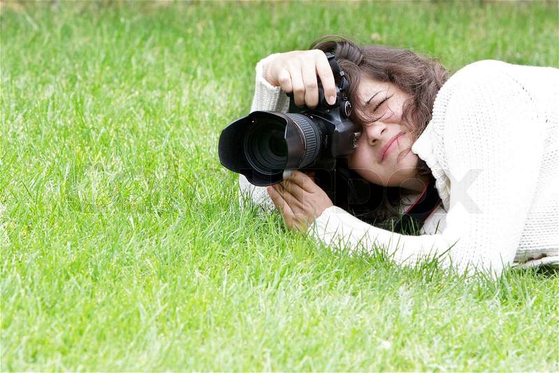 Girl taking pictures on natural background, stock photo