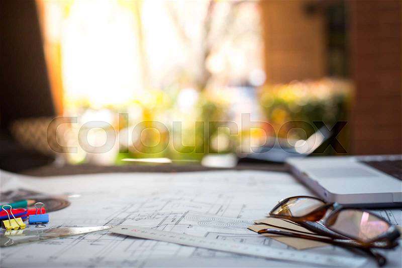 Architectural Office desk background construction project ideas with warm light, stock photo