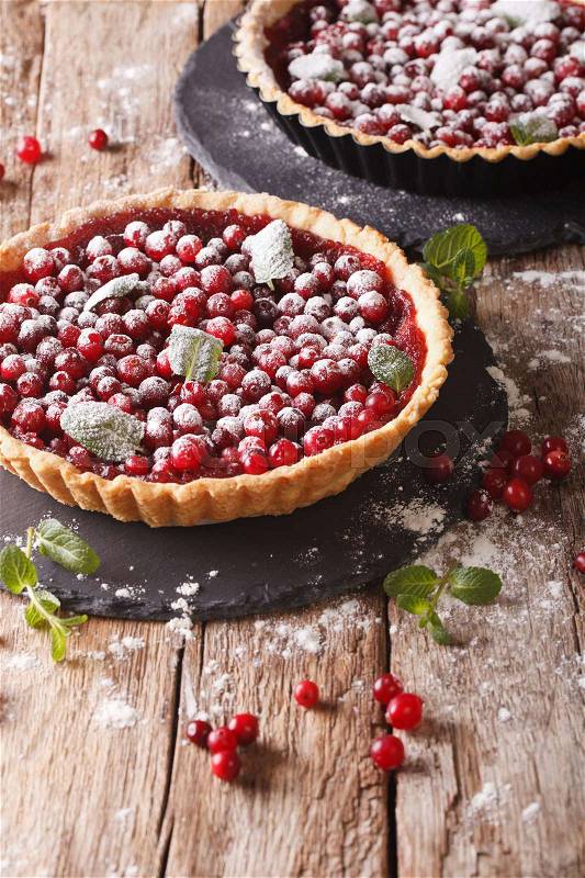 Cranberry tart with jam, powdered sugar and mint close-up on the table. vertical\, stock photo