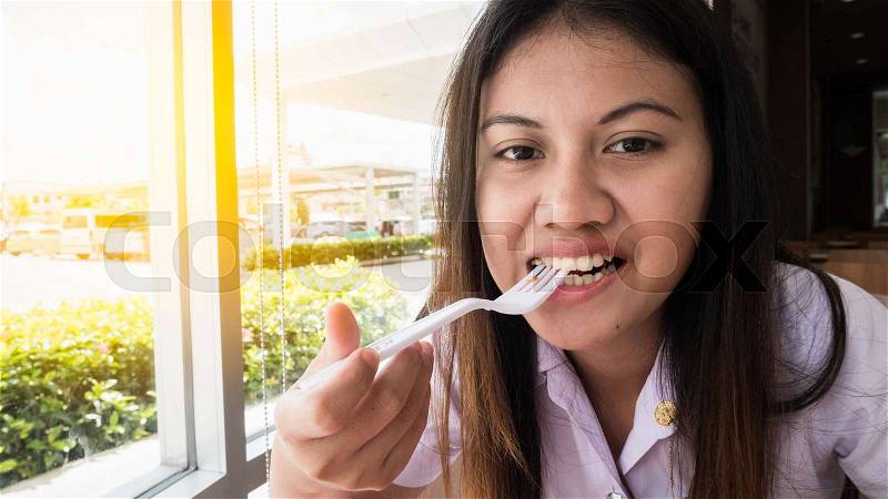 Still-life Close up women mouth eating with fried spoon in restaurant, stock photo