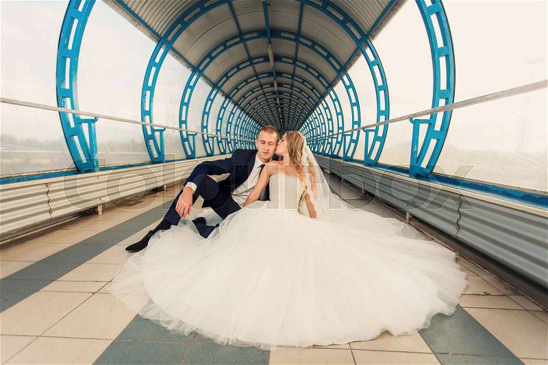 Wedding couple in big futurustic blue tunnel, stock photo