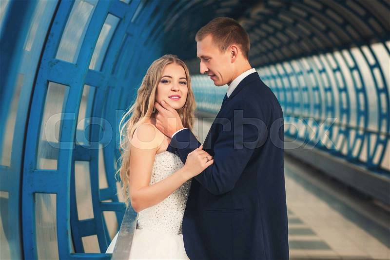 Wedding couple in big futurustic blue tunnel, stock photo
