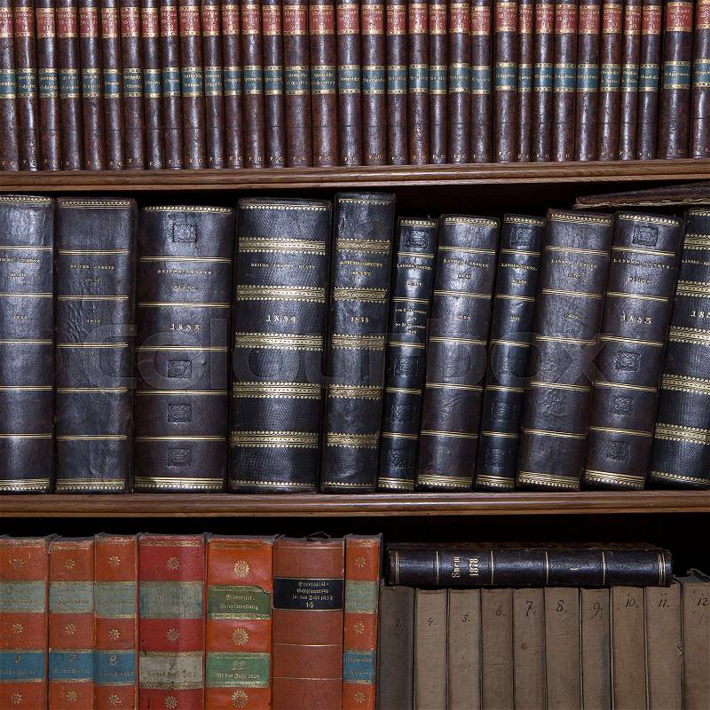 Old books in a wooden row library, stock photo