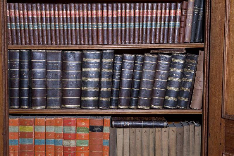 Old books in a wooden row library, stock photo
